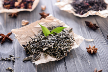 Heap of dry green tea leaves on paper