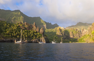 Sailing yachts anchoring in the Bay of Vergins, Marquesas Islands, French Polynesia
