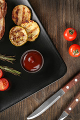 Plate with vegetables and barbecue sauce on table, top view