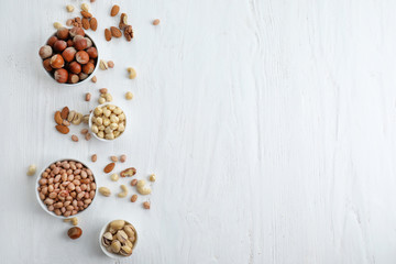 Flat lay composition with different kinds of nuts on light background