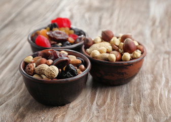 Bowls with mix of dried fruits, berries and nuts on wooden background