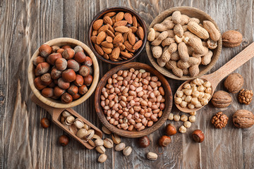 Flat lay composition with different kinds of nuts on wooden background