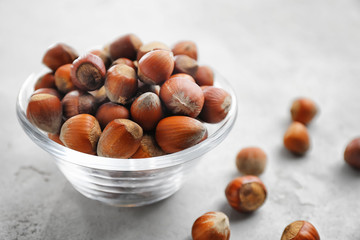 Obraz premium Bowl with hazelnuts on grey background