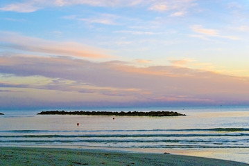 The outfall on sand beach. Beautiful sunrise sky over Adriatic sea