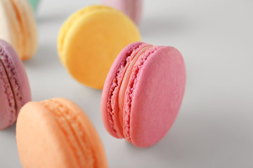 Tasty colorful macarons on white background, closeup