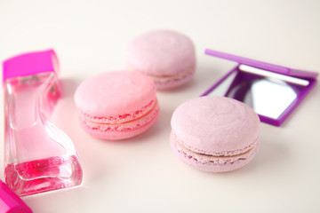 Tasty macarons with accessories on white background
