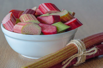 Close-up of slised rhubarb in a bowl on wooden background