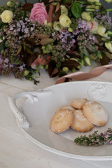 A beautiful cookie on a platter. Flowers in the background
