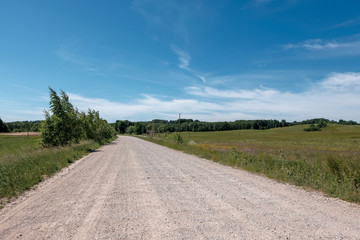 empty gravel road in the countryside in summer heat