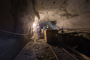 Fototapeta na wymiar Underground old ore gold mine tunnel shaft passage mining technology with locomotive