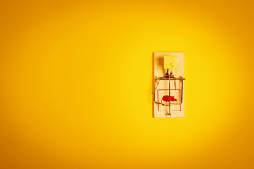 minimalistic yellow background with a mousetrap and a piece of tasty cheese