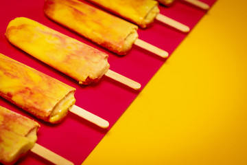 isolated delicious yellow-red ice cream on a colorful summer background
