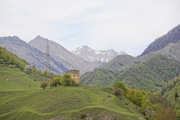 Naklejka premium Mountain landscape with an ancient signal tower on the Georgian Military Road in the valley of the Terek river, horizontal image, Caucasus, Georgia (Europe)