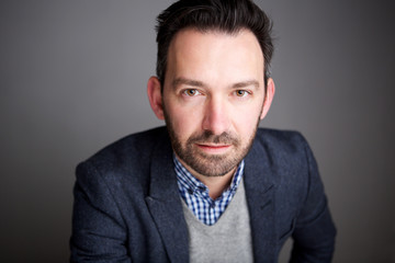 Obraz premium Close up businessman with beard against gray wall