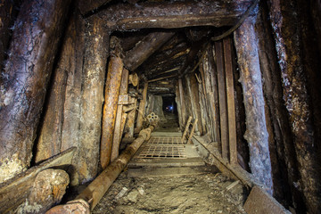 Fototapeta na wymiar Underground emerald ore mine shaft tunnel gallery with timbering