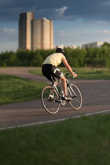 Obraz premium Cyclist man riding road sport bike in sunny day on a mountain road