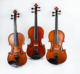 Fototapeta na wymiar The triple violin put on background,the violin has two strings put at the left side,blurry light around.