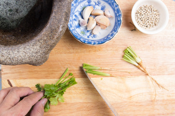 Chef cutting coriander on wooden board