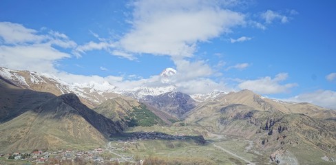Fototapeta premium Panoramic view of the glacier peak Kazbek in the clouds, Caucasus, Kazbegi District, Georgia (Europe)