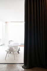 Warm cozy modern style bathroom with bathtub with natural light and view