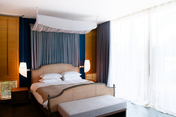 Colonial style bedroom wooden bed with curtain, pillows and lamp