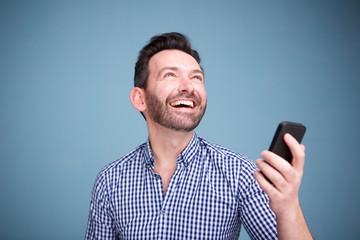 Close up happy man holding cellphone and looking up