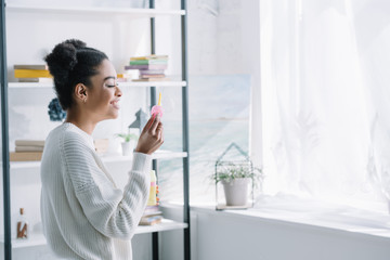 side view of beautiful young woman with soap bubbles at home