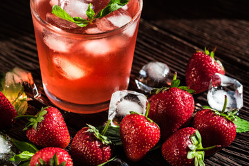 Homemade srawberry mojito and berries on wood