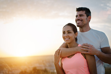Couple healthy and fitness lifestyle. Happy sporty lovers portrait during outdoor training at sunset. - 208409461