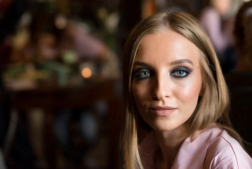 Portrait of pretty young blonde model in restaurant