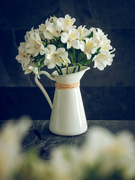 Pitcher with white blooming bouquet
