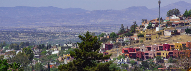 Hilltop View of Houses and Valley with Mountains in the Distance