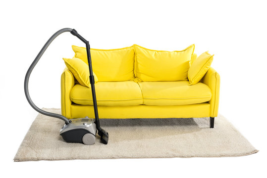 Bright Yellow Sofa And Vacuum Cleaner On Carpet Isolated On White