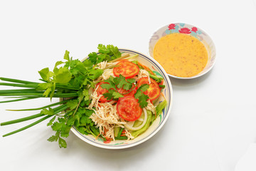 dish of salad and salad dressing on white background