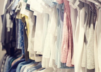 Various women's clothing of different flowers and styles on a hanger in shop, selective focus