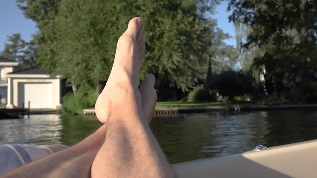 F&uuml;&szlig;e liegen relaxt in der Sonne auf dem Rand eines Bootes bei voller Fahrt