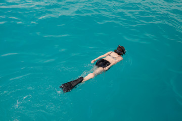 Woman swimming with snorkel and paddles