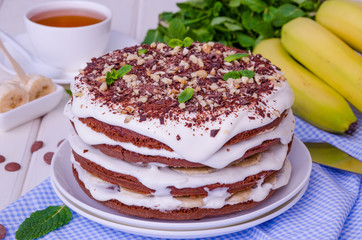 Chocolate cake with cream and bananas. Rustic style