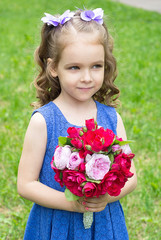 Beautiful child girl with bouquet of roses. 