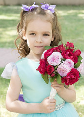 Beautiful child girl with bouquet of roses. Tender portrait 