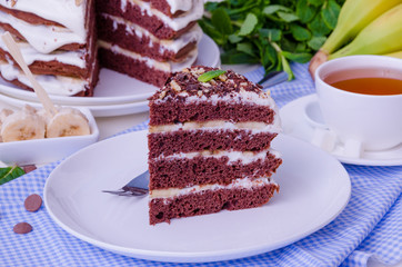 Chocolate cake with cream and bananas. Rustic style