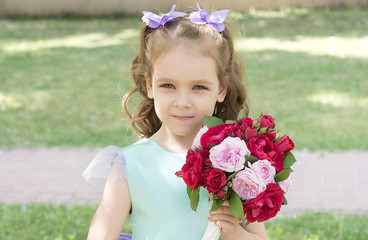 Beautiful child girl with bouquet of roses. Tender portrait 