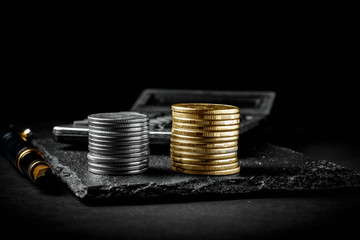 A fountain pen, calculator, silver and golden coins. Business,finance or investment concept.