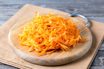 Grated carrots on a wooden cutting board