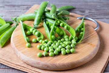 Fresh green peas on old cutting board
