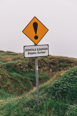warning signs of slippery surface and unprotected edges at the iconic Dunquin harbour pier surroundings in county Kerry