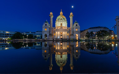 Vienna, Austria, night view of the St Charles church at full moon reflected in the pond