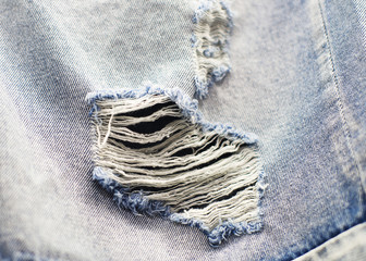 Fototapeta na wymiar Hole on blue jeans. Close up blue jean texture 