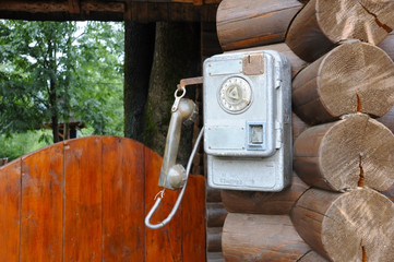 The old Soviet phone hangs on a wooden house