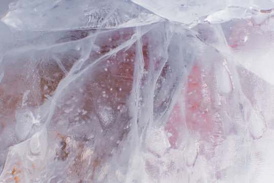 Cracled translucent ice texture  with pinkish and orange picking from underneath